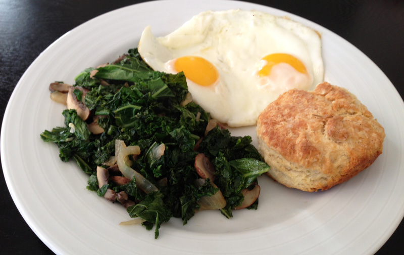 An example of a brunch meal at home: sauteed kale & mushrooms; eggs; biscuit